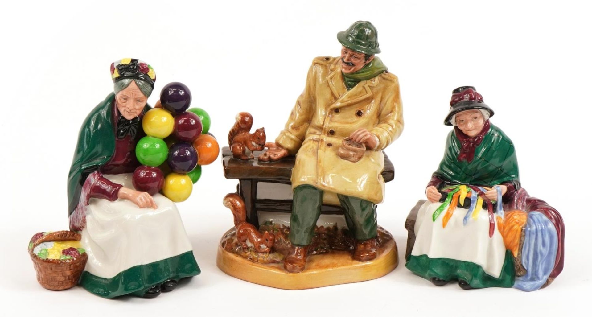 Three Royal Doulton figures comprising Lunchtime HN2485, The Old Balloon Seller HN1315 and Silks &