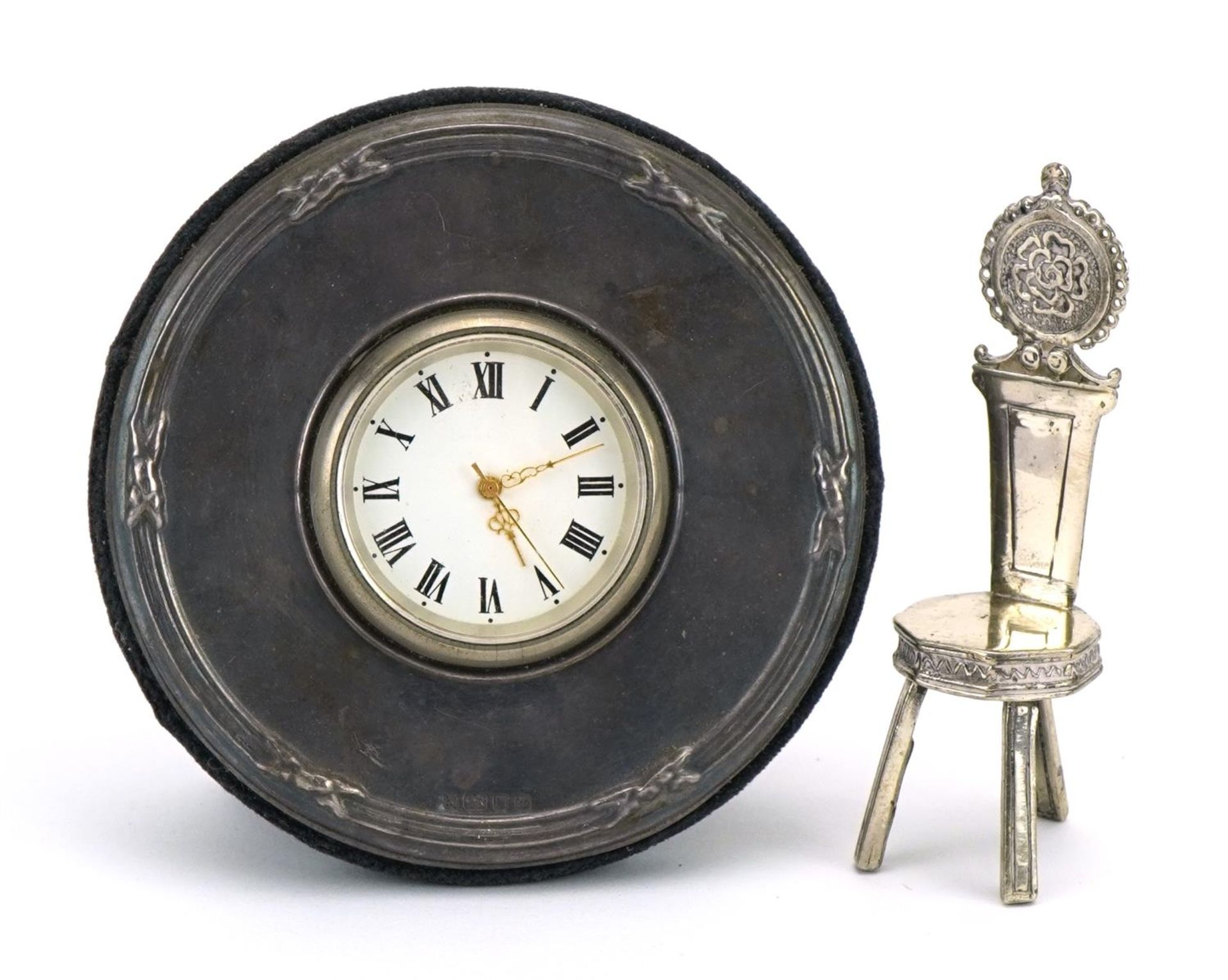 Circular silver mounted easel clock and a silver doll's house chair decorated with a Tudor rose, the