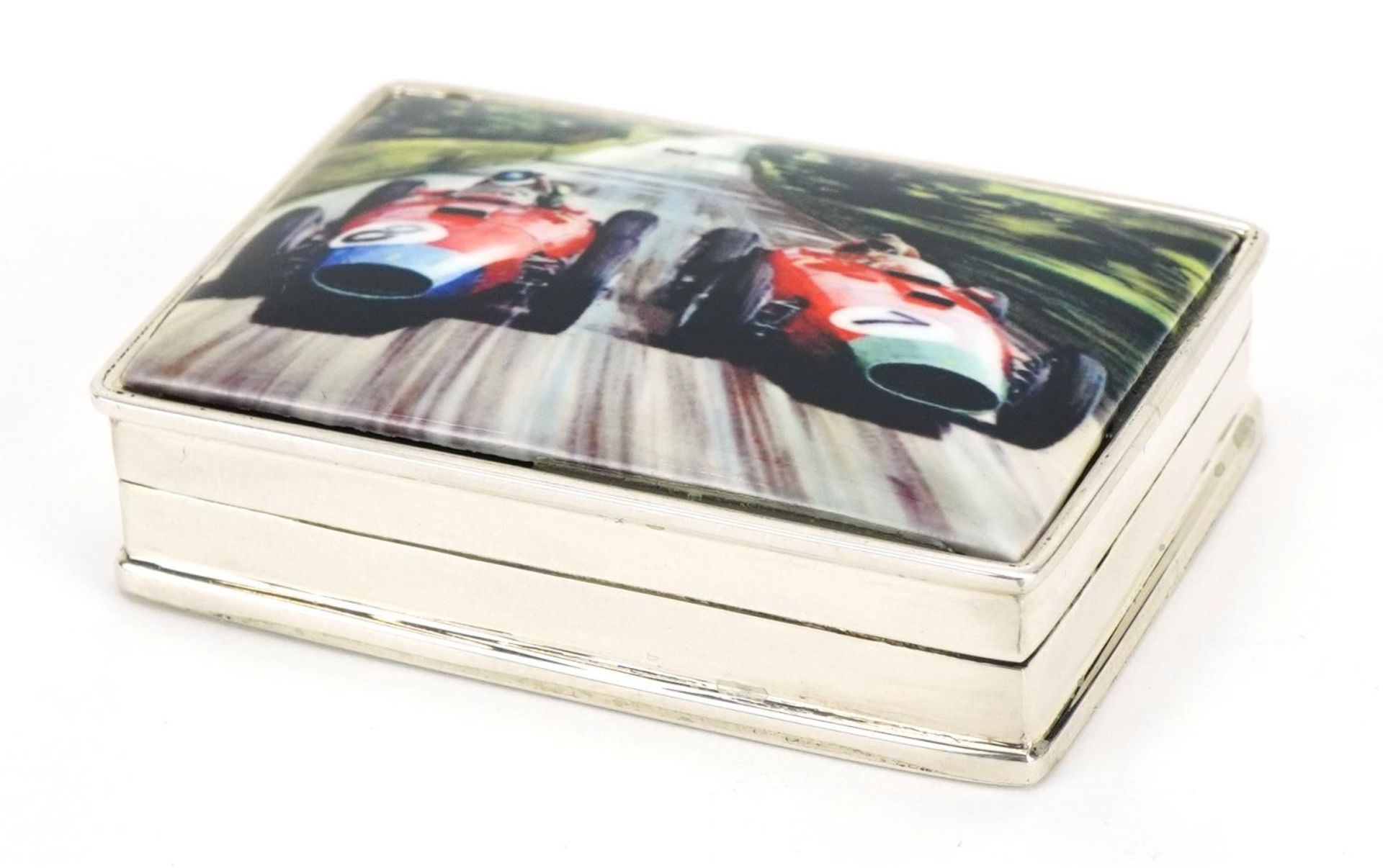 Rectangular silver and enamel pill box, the hinged lid decorated with Formula 1 cars, 5cm wide, 39.