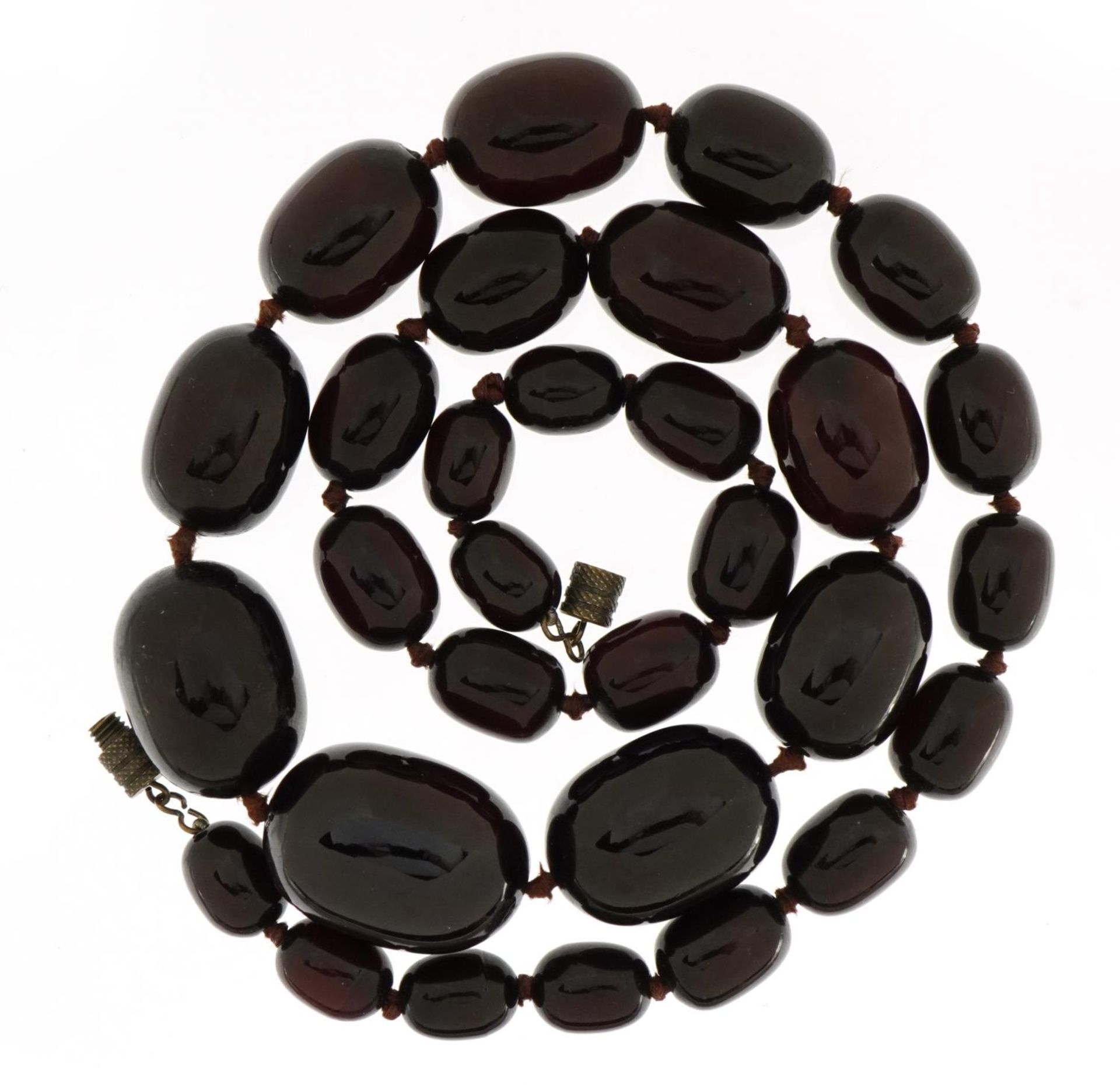 Cherry amber coloured graduated bead necklace, the largest bead 2.8cm in length, the necklace 63cm - Image 2 of 2