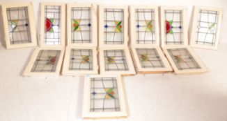A collection of twelve vintage 20th century stained glass windows of square form having polychrome