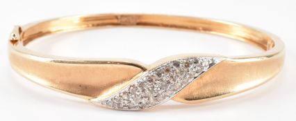 A GOLD AND ROUND OLD CUT CROSSOVER BANGLE