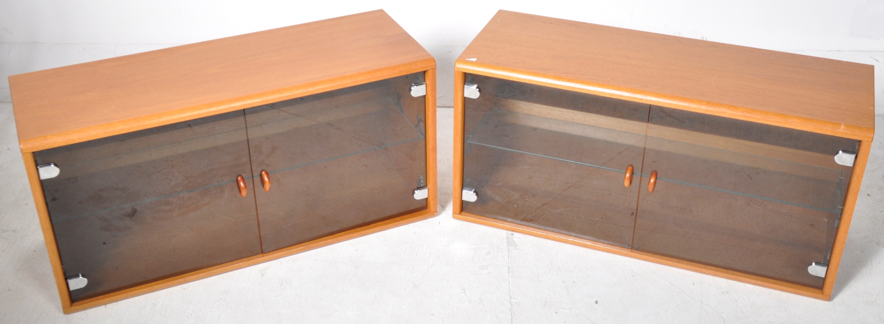 MATCHING PAIR OF MODULAR TEAK AND SMOKED GLASS CABINETS