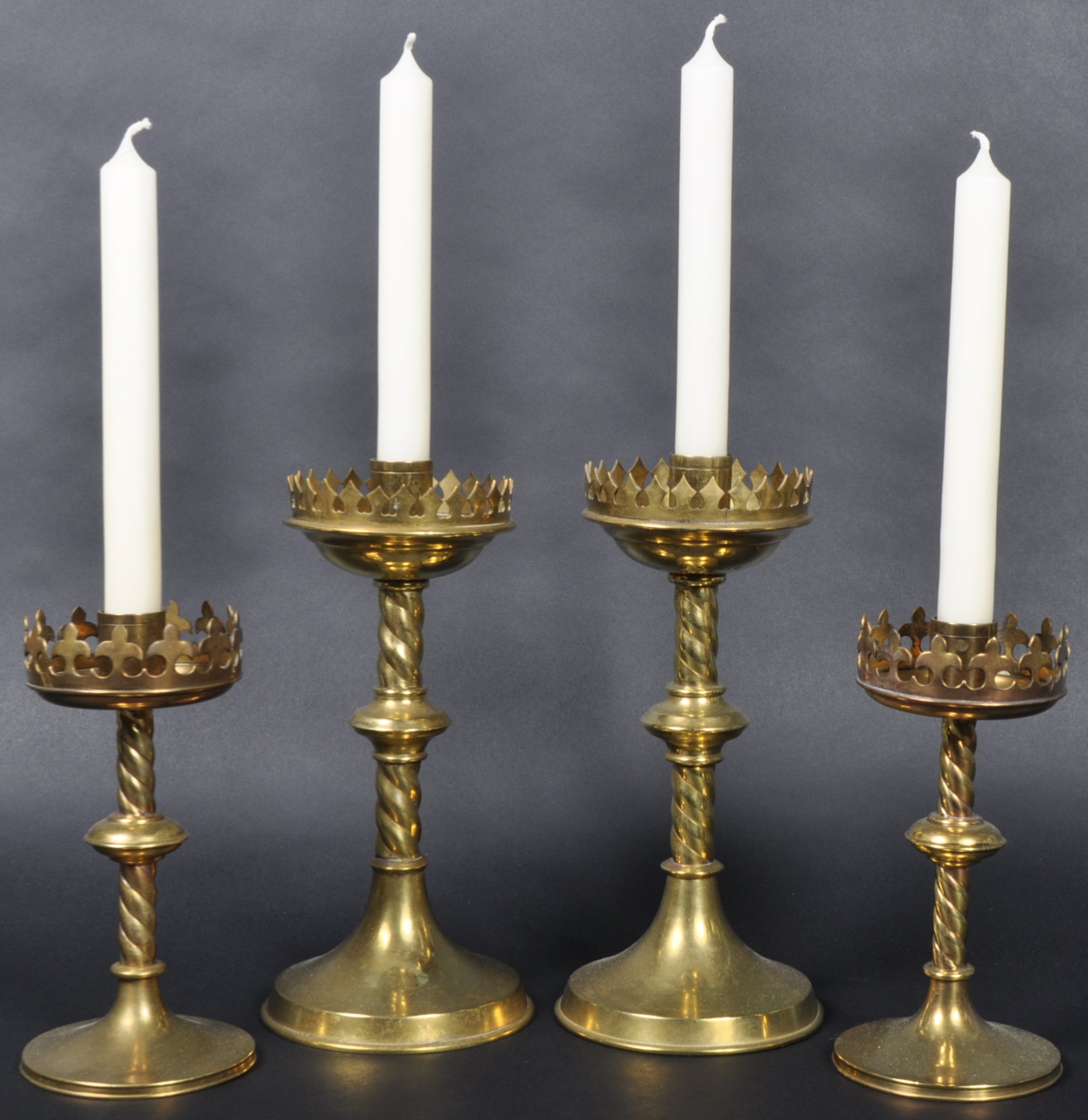 TWO PAIRS OF 19TH CENTURY GOTHIC BRASS CANDLESTICKS