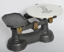 PAIR OF EARLY 20TH CENTURY CAST METAL & CERAMIC SHOP SCALES