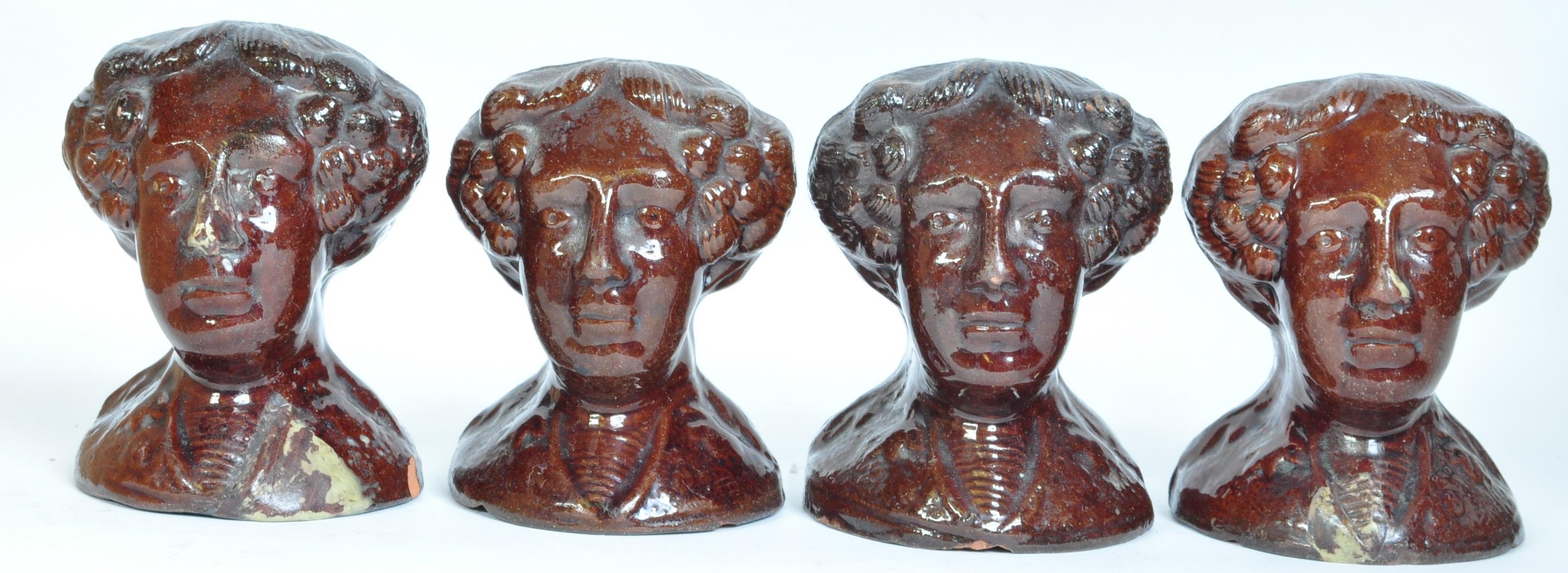 A SET OF FOUR VICTORIAN TREACLE-GLAZED POTTERY SASH WINDOW RESTS