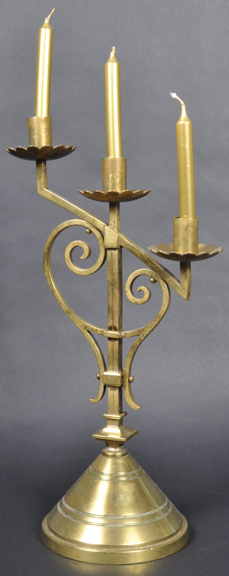 LATE 19TH CENTURY GOTHIC POLISHED BRASS TRIPLE CANDLESTICK
