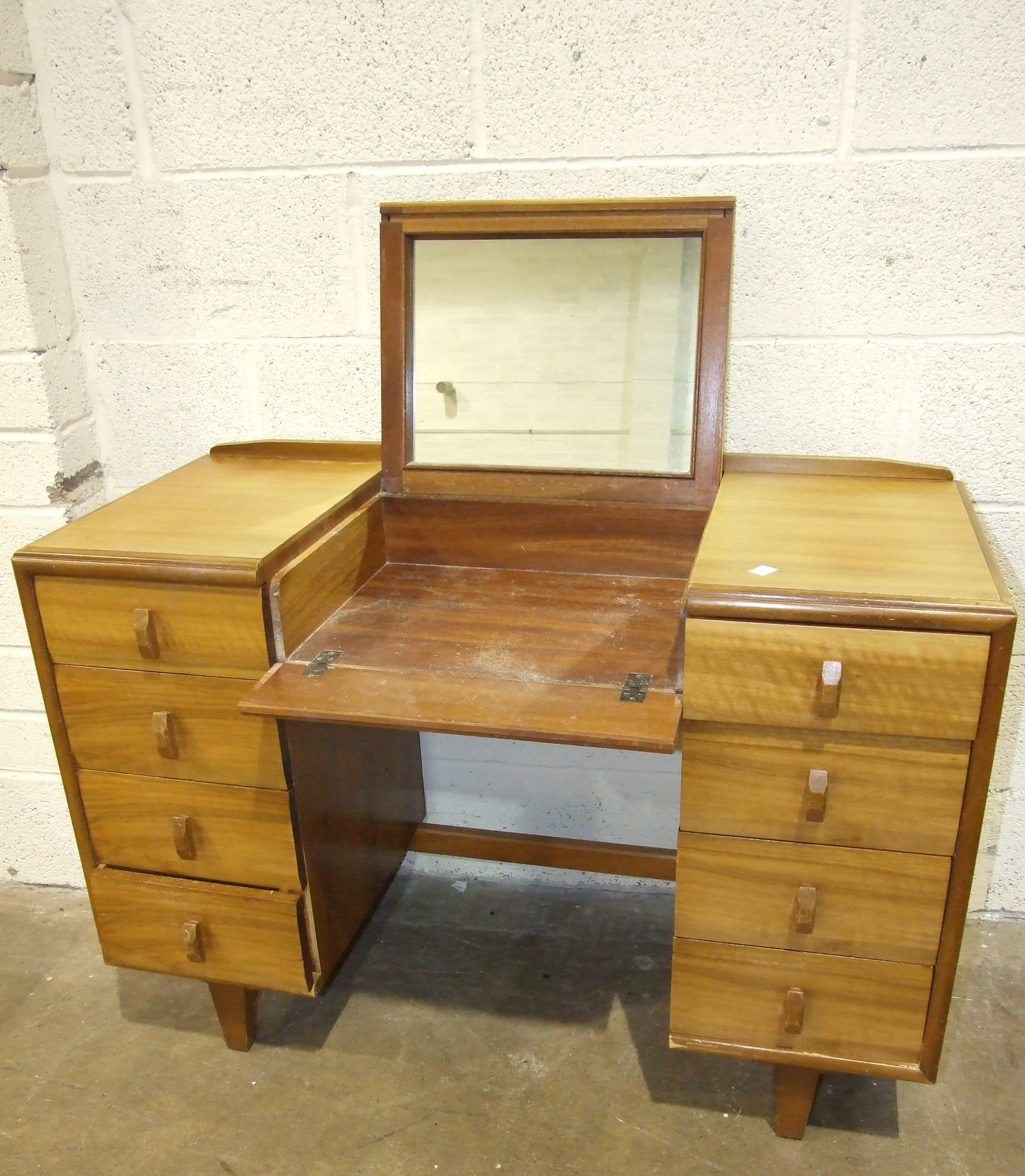 A mid-20th century knee-hole dressing table with folding mirror and eight drawers, 107cm wide, a