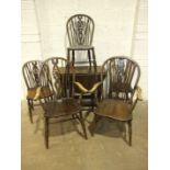 A stained elm and beech wheel-back armchair, three similar side chairs and another armchair, an