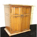 A smoker's compendium in the form of an oak two-door wardrobe, 25.5cm wide, 28.5cm high.