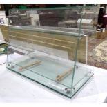 A shop counter top three-tier glass display shelves, 60.5cm wide, 45.5cm high, 30.5cm deep at base.