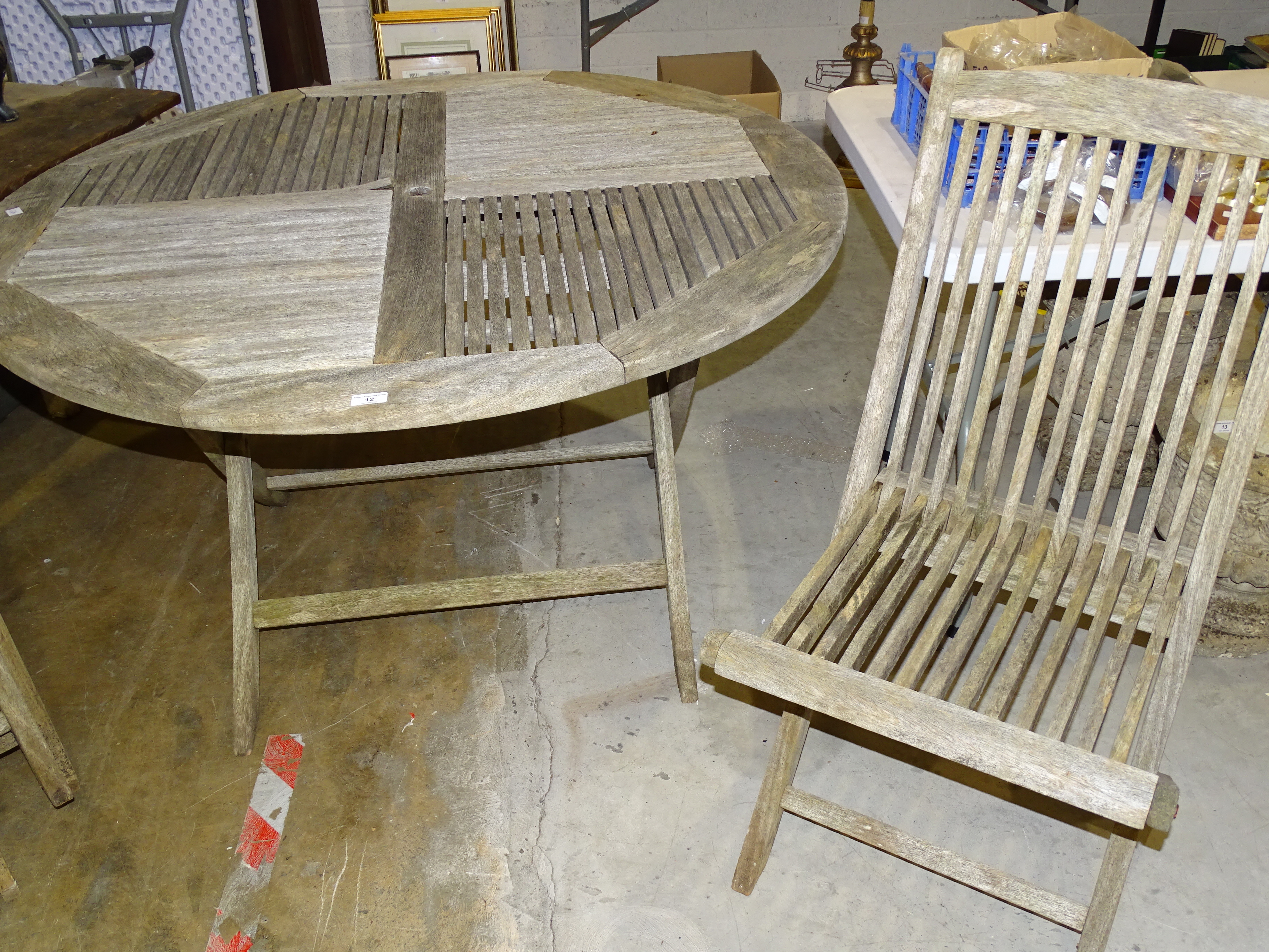 A weathered teak circular slatted-top patio table, 125cm diameter and four matching folding chairs. - Bild 2 aus 2