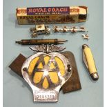 A combination propelling triple pencil, a metal AA car badge, a brass pestle and mortar, various