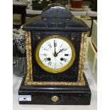A Victorian black slate mantel clock of architectural form, with bell-striking movement, stamped GR,