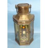 An early-20th century brass oil lamp, with three glazed side panels enclosing an oil lamp burner, by