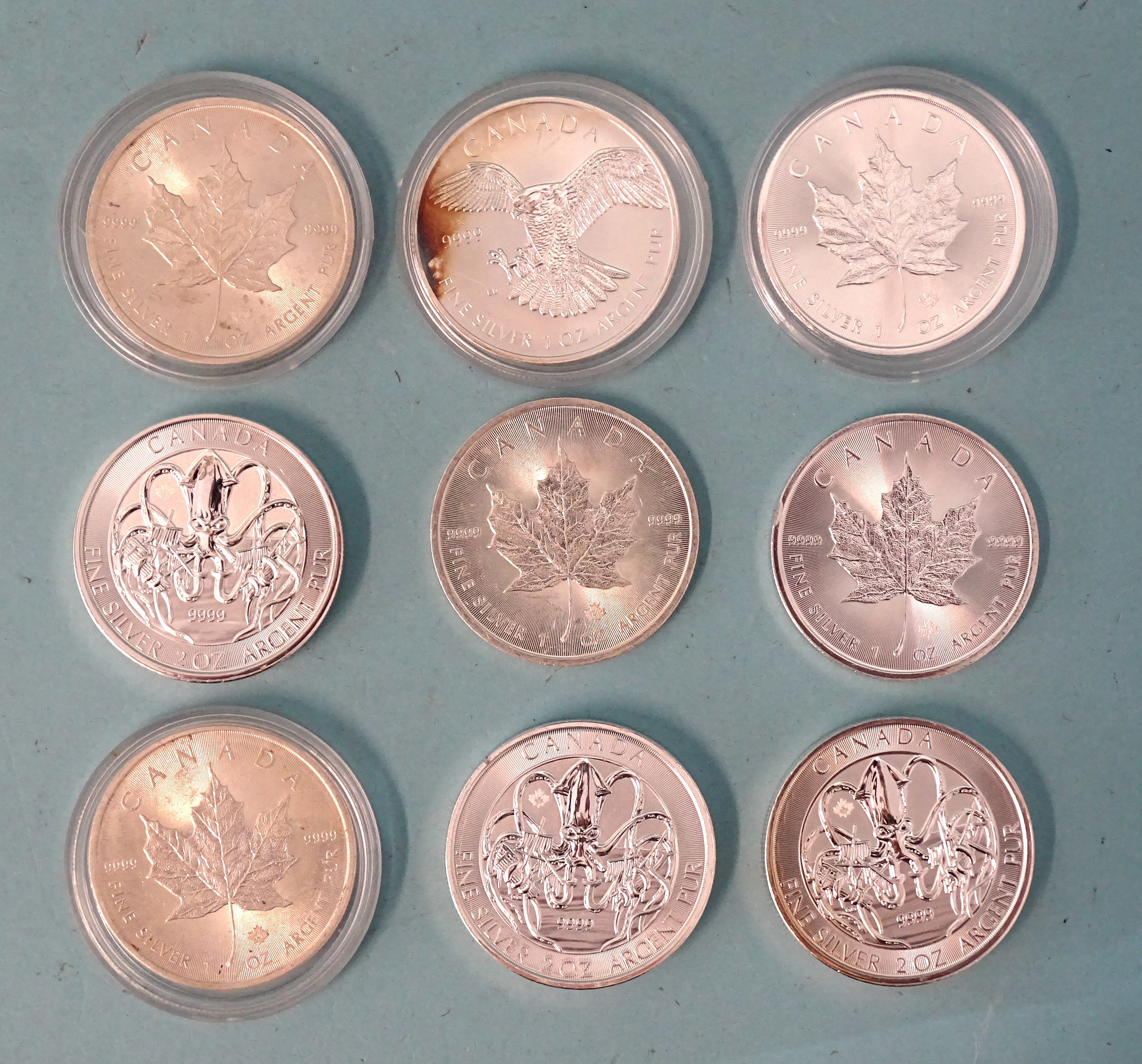 A collection of nine Canada silver bullion coins: three 'The Kraken' ten-dollar coins and six 'Maple