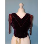 An early-Victorian plum-coloured velvet bodice, the neckline trimmed with faceted red glass beads,