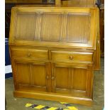 An Ercol 'Golden Dawn' elm bureau fitted with a fall front above two drawers and two cupboard doors,
