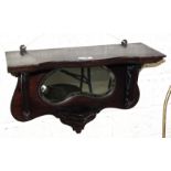 A stained wood wall bracket with shaped mirror, a carved hardwood elephant's head, a plated