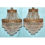 A pair of four-stage gilt metal hanging light fittings with cut-glass drops, complete with ceiling