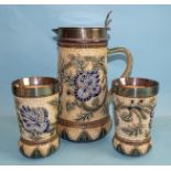 A Doulton Lambeth stoneware lemonade set comprising a lidded jug and a pair of beakers incised