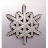 A white enamelled silver brooch in the form of a snowflake by Ottar Hval, Oslo, 43 x 37mm, 9.6g.