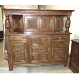 A large Continental carved oak court cupboard, the cornice on baluster supports enclosing a pair