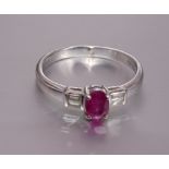 A ruby and diamond Deco-style ring claw-set an oval ruby between two pairs of baguette-cut diamonds,