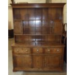 A Georgian inlaid oak dresser, the dentil cornice above shelves and two small doors, the base fitted