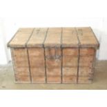 A Continental large planked-wood chest with overall iron bindings, three-quarter hinged lid and