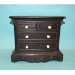 A 19th century English carved slate miniature bow-fronted chest of four drawers, 23cm wide.