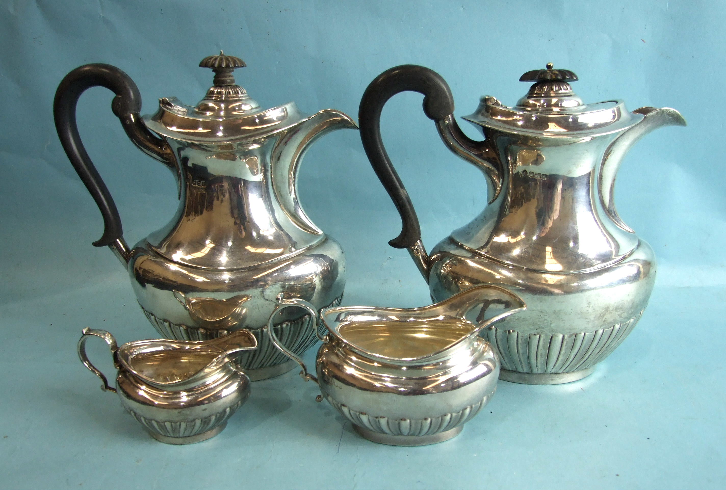 A four-piece silver coffee service of half-gadrooned bellied form, comprising: coffee pot, hot water