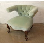 A walnut tub-shaped low armchair, with button back and serpentine seat on short carved cabriole