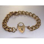 A 9ct gold bracelet of flattened curb links, with padlock clasp, 19cm, 34.8g.