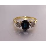 A sapphire and diamond ring claw-set an oval sapphire between two illusion-set brilliant-cut