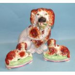 A pair of 19th century Staffordshire pottery models of reclining spaniels on cushion bases formed as