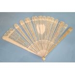 A 19th century ivory brisé fan, each stick finely pierced in geometric patterns, with central shield