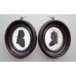 A pair of oval silhouettes portraits on plaster, possibly Robert Bogle and Margaret Bogle, each 9