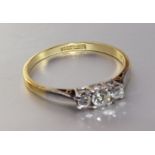A three-stone diamond ring claw-set brilliant-cut diamonds, in 18ct gold and platinum mount, size