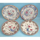 A pair of Chinese porcelain famille rose plates decorated with flowering shrubs within formal shaped