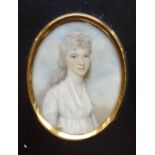 An early 19th century oval portrait miniature of a young woman wearing a white dress, three-