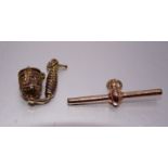 A 9ct gold T-bar and a 9ct gold charm in the form of a German pipe, total weight 6.7g.