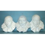 A set of three moulded plaster wall plaques, each in the form of a clown's head wearing a