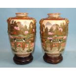 A pair of small baluster Satsuma decorated Japanese vases, with lion mask handles and figures in a