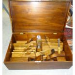 A mahogany chest, 61cm wide, containing twelve wooden moulding planes, a 22" wooden jack plane