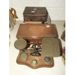 A set of brass postal scales and weights on wooden base, 28cm long, a South Asian copper rectangular