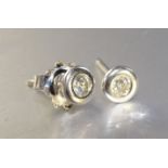 A pair of diamond and platinum ear-studs, each collet set a brilliant cut diamond of approximately
