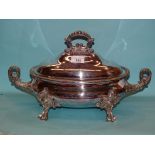 A plated two-handled tureen and cover of oval form on four applied supports, 45cm long, 26cm high.