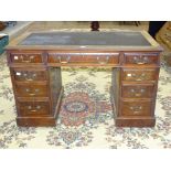 An Edwardian oak knee-hole desk, 121cm wide and a mahogany circular extending dining table on