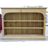 A stripped pine open bookcase with adjustable shelves, 125cm wide, 90cm high, 26cm deep.